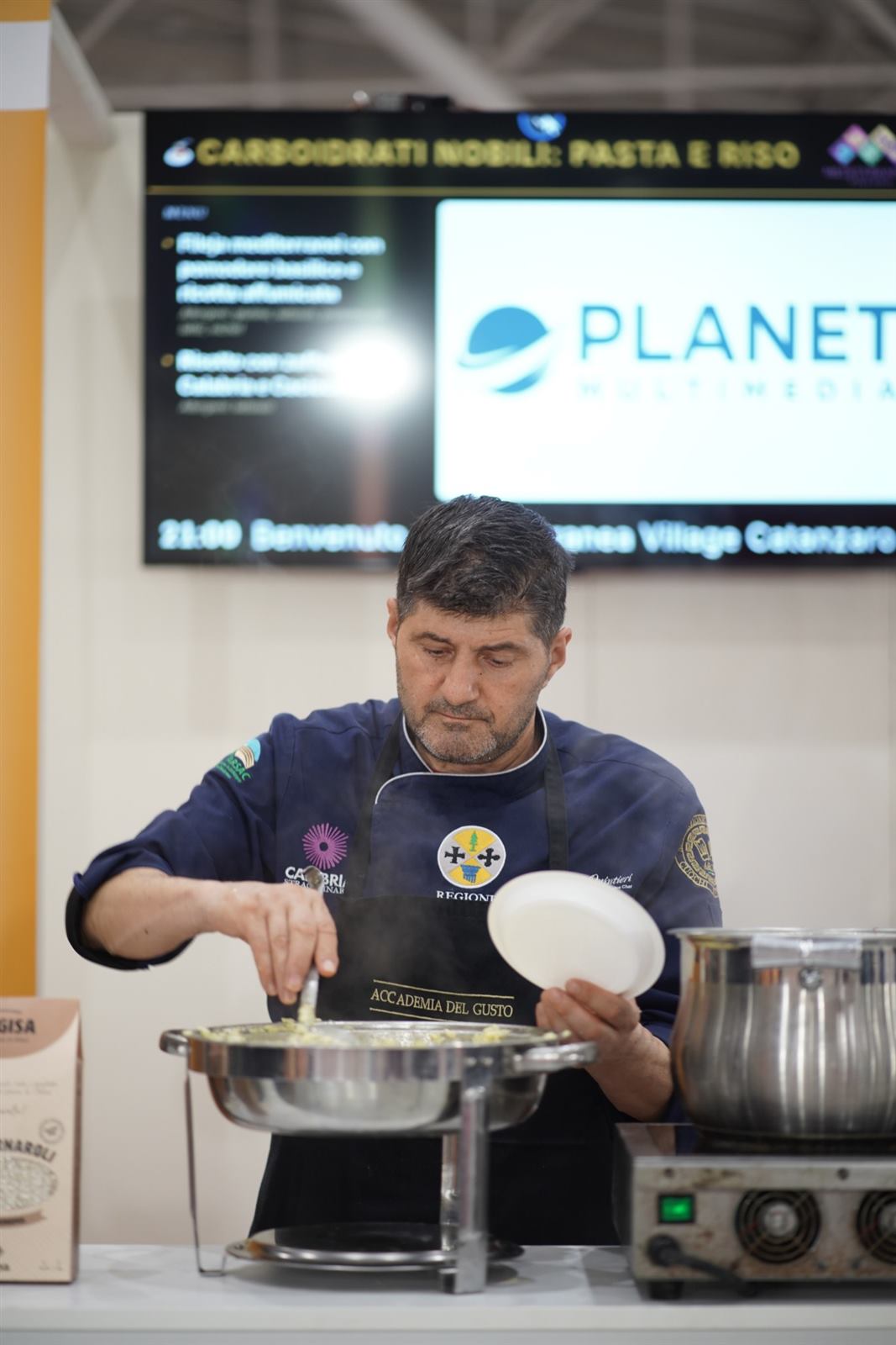 Chef serve un piatto nell’area Carboidrati nobili: pasta e riso